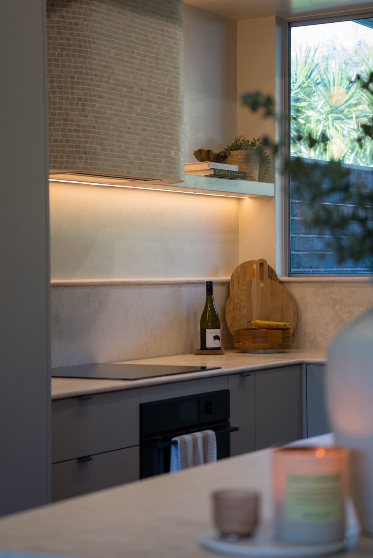 Kitchen & island — Cronulla — Stone island bench looking back to the cooktop, joinery and garden window.