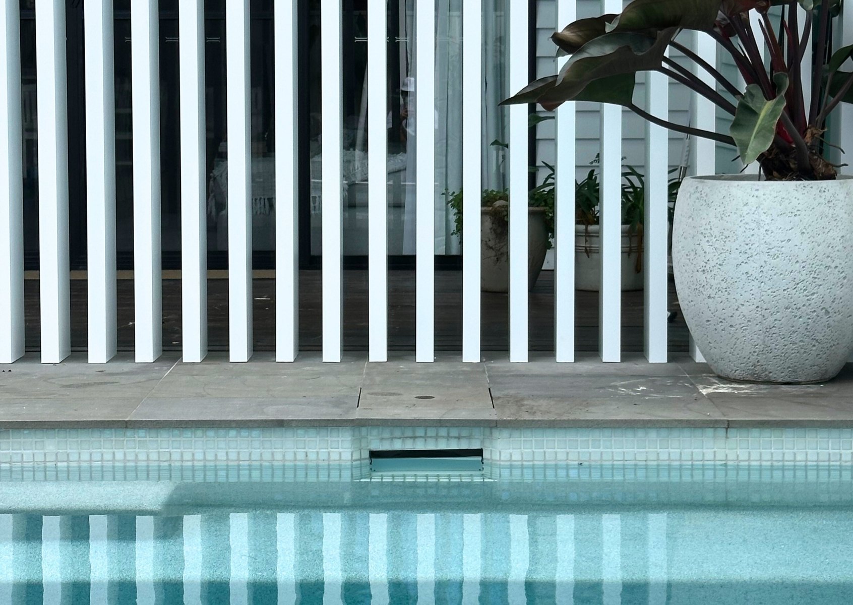 Pool with vertical screen feature — Vertical timber screen built alongside a pool for privacy and shade.